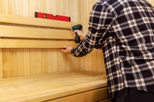 Drilling timber in a sauna | SDS Australia A person drilling timber in a sauna